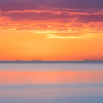 Long exposure of Lake Superior at sunrise with purple rain clouds and pinks and blues